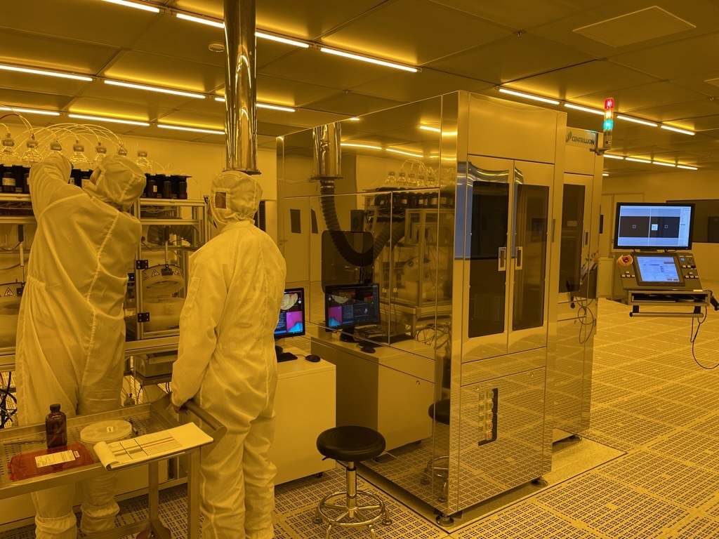 Centrillion team operating the lithographic production system in a yellow safe-light cleanroom